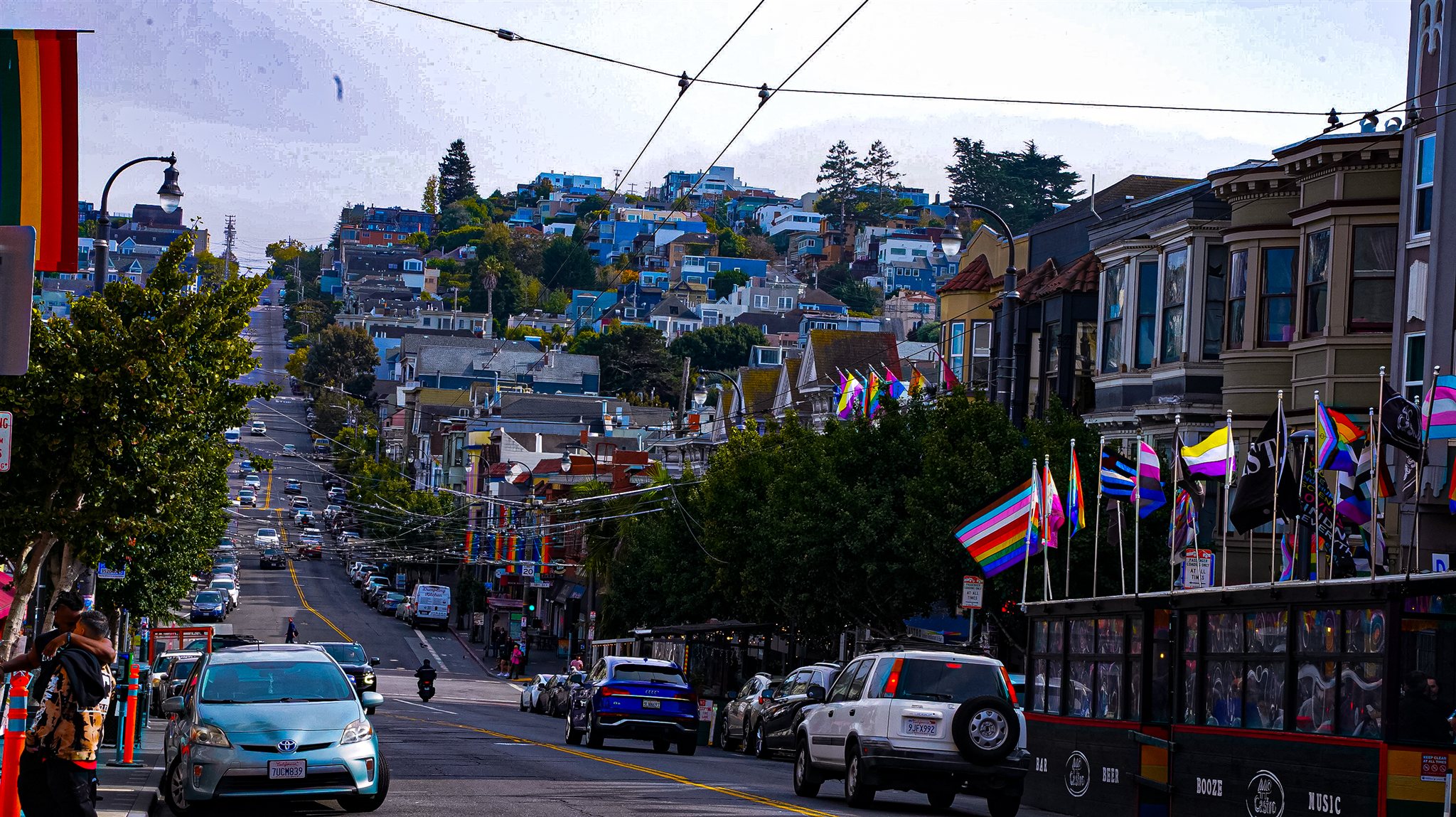 Castro neighborhood street, hillside homes, and rainbow flags
