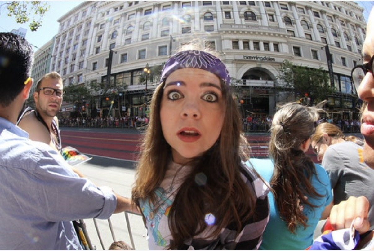Fisheye portrait of a spectator beside a street event barricade
